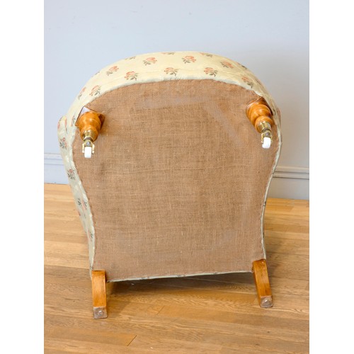 360 - A Victorian style upholstered armchair, with button back and scroll arms, the front legs raised on p... 