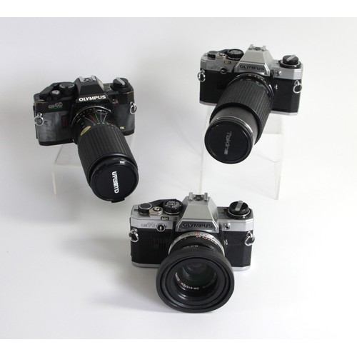 165 - Two Olympus Om10 35mm cameras, together with an Olympus OM40 programme 35mm camera, manual, with 3 l... 