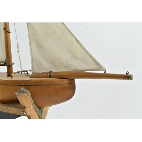 195 - A vintage solid wood gaff rigged pond yacht with varnished hull and metal keel and rudder, 53 x 61cm... 