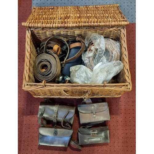 146 - Four leather vintage tool bags, various leather belts and buckles, contained in a wicker basket