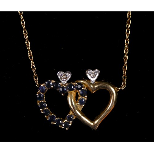 69 - A 14K gold, brilliant cut diamond, ruby and sapphire entwined heart pendant, one side set with rubie... 