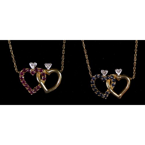 69 - A 14K gold, brilliant cut diamond, ruby and sapphire entwined heart pendant, one side set with rubie... 