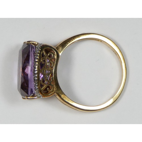 71 - A 9K gold, amethyst and brilliant cut diamond dress ring, claw set with a mixed cut stone, flanked b... 