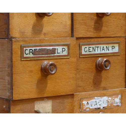 144 - A Victorian set of 30 Apothecary pitch pine drawers, most with the original glass medicine plaques, ... 