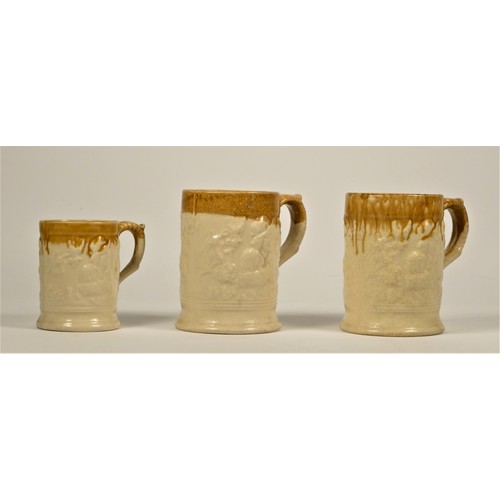 185 - Two Kilnhurst/Twigg pottery pint mugs and a half pint mug, each with moulded decoration and brown ri... 