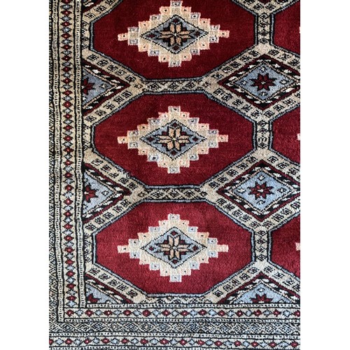 275 - A Pakistani Bokhara rug, with multiple guls on a red field, 238 x 350cm.