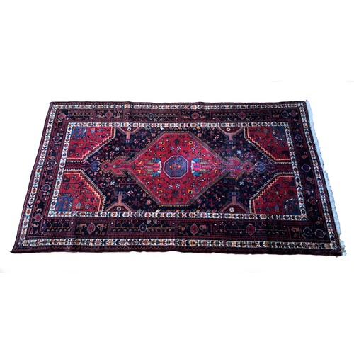 277 - A Persian Tuyserkan Hamaden wool rug, medallion design predominantly in red, blue and cream, 139 x 2... 