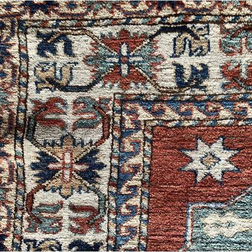 279 - A Caucasian Kazak rug, with brick red field, 180 x 195cm