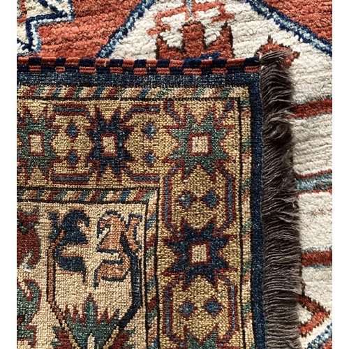 279 - A Caucasian Kazak rug, with brick red field, 180 x 195cm