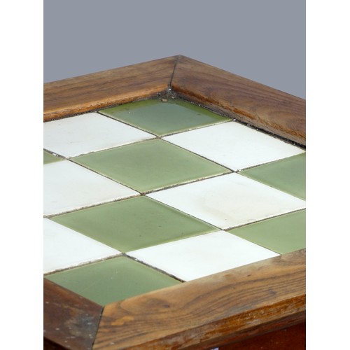 297 - An Arts and Crafts oak tapering occasional table, with chequerboard tile insert, 40 x 70cm.