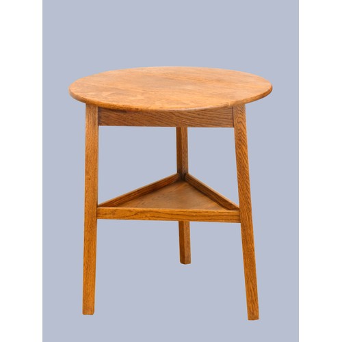 305 - An early 20th Century oak cricket table, the circular top above three outswept legs united by an und... 