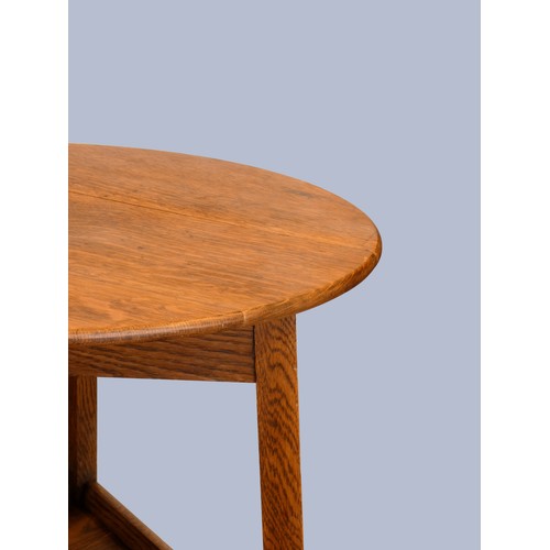 305 - An early 20th Century oak cricket table, the circular top above three outswept legs united by an und... 