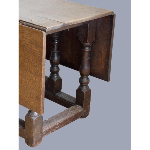 313 - A late 17th century oak gate leg table, with associated rectangular plank top, raised on baluster le... 