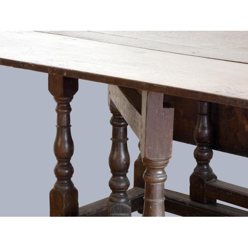 313 - A late 17th century oak gate leg table, with associated rectangular plank top, raised on baluster le... 