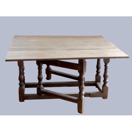 313 - A late 17th century oak gate leg table, with associated rectangular plank top, raised on baluster le... 