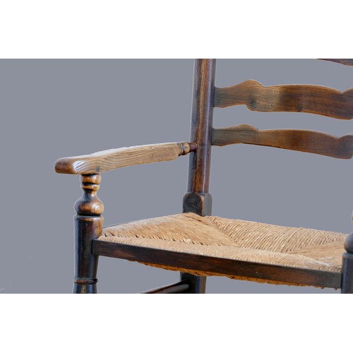 315 - An 18th century oak ladder back rocking chair, with rush seat