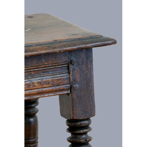 322 - A 17th century oak joint stool, with plank top and thumb nail edge, line incised frieze, on turned b... 