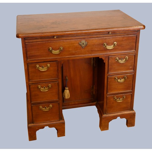 323 - A George III mahogany kneehole desk, with shaped top, pull out writing slide, over a single frieze d... 