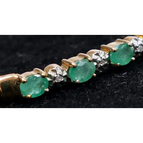 73 - A 9ct gold emerald and diamond line bangle, internal 18cm, 4.6gm