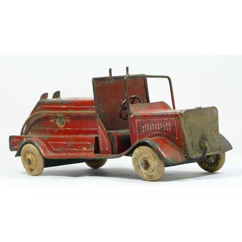 228 - A vintage red painted metal fire engine, probably American, white rubber tyres, lacking ladder, 30cm... 