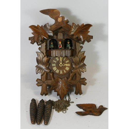 76 - A mid 20th century Black Forest cuckoo clock, having three weights with musical carousel.