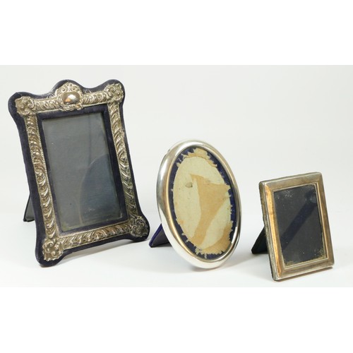 107 - A silver photograph frame, London 1985, with embossed decoration, 20 x 15cm and two other silver mou... 