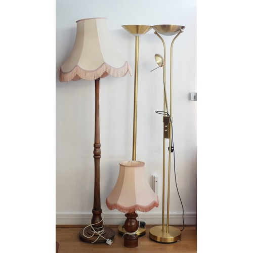 297 - Three standard lamps to include two modern brass uplighters, a turned wood example and a table lamp.... 