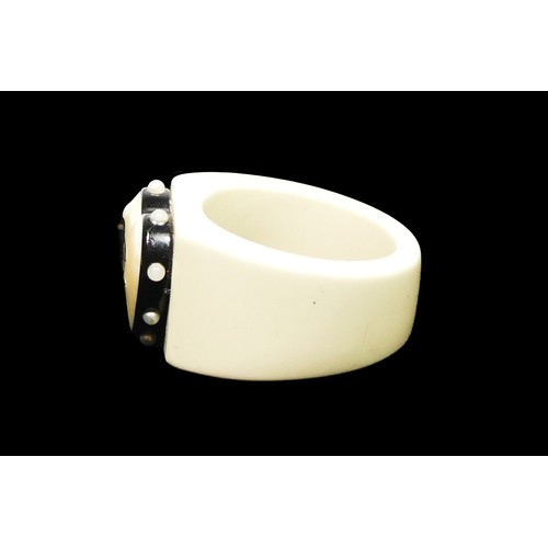44 - Chanel, a white resin band ring, c.2000's, with applied heart inset with double C's, plague to insid... 
