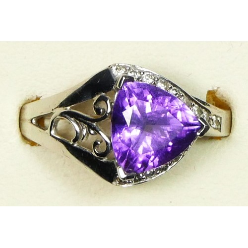 59 - A 9ct white gold amethyst and diamond dress ring, the triangular cut stone flanked by brilliants, P ... 