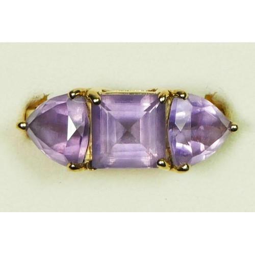 69 - A 9ct gold and amethyst three stone ring, the 8mm square cut stone flanked by triangular stones, N 1... 