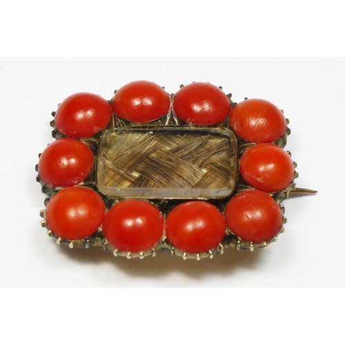 54 - A Georgian gold mourning brooch, with woven hair panel bordered by cabochon coral buttons, 30 x 26mm... 