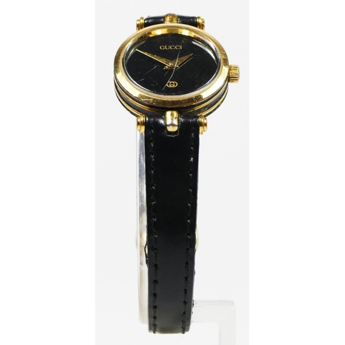 111 - Gucci, a gilt metal and black enamel quartz ladies wristwatch, 22mm, recent battery, case