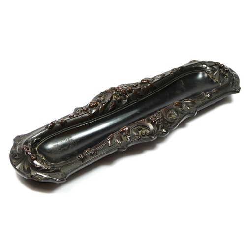 135 - A 19th century French carved lignum vitae pen tray, with mask and floral decoration, 31 x 10cm.