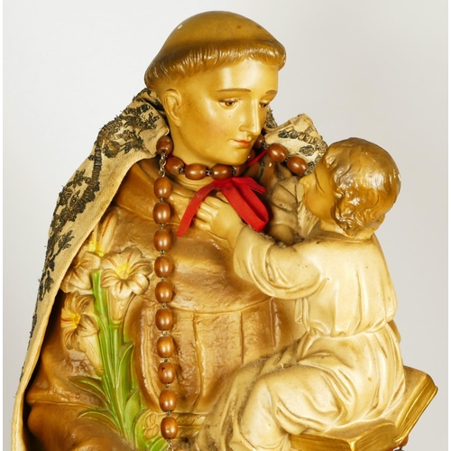 174 - An early 20th century painted plaster statue of St Antony of Padua holding the infant Jesus, 63cm.