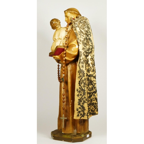 174 - An early 20th century painted plaster statue of St Antony of Padua holding the infant Jesus, 63cm.