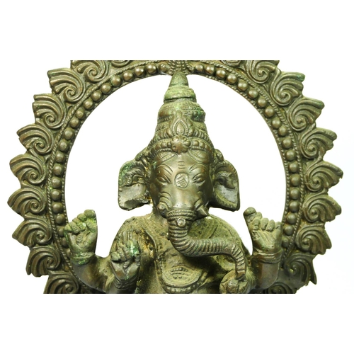 216 - An Indian brass seat Ganesh statue, with hoop behind, 33cm.