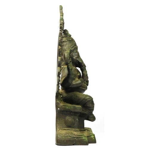 216 - An Indian brass seat Ganesh statue, with hoop behind, 33cm.