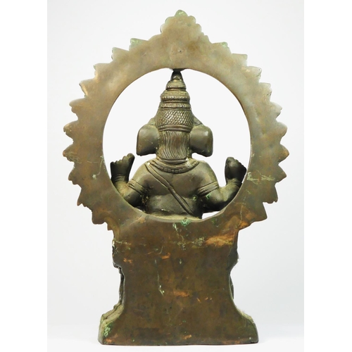 216 - An Indian brass seat Ganesh statue, with hoop behind, 33cm.