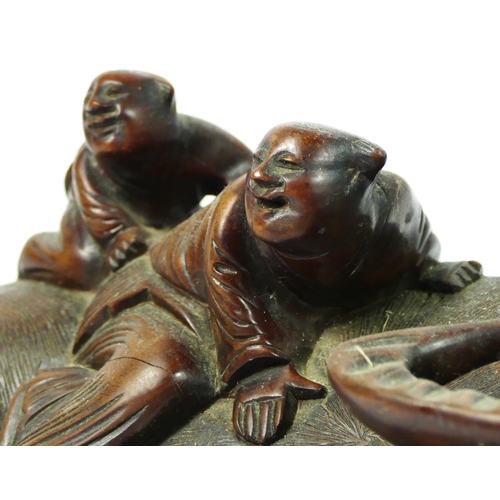 257 - A Chinese pair of carved hardwood recumbent water buffalo with two riders, glass eyes, 36 x 15cm.