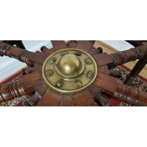 76 - A 20th century oak and brass bound ships wheel, central boss, mounted on three brass table legs, dia... 