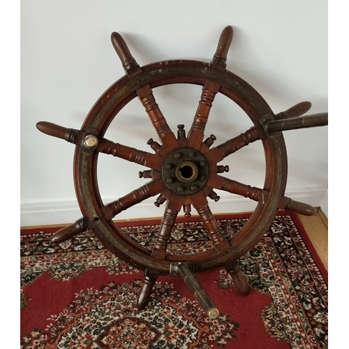 76 - A 20th century oak and brass bound ships wheel, central boss, mounted on three brass table legs, dia... 