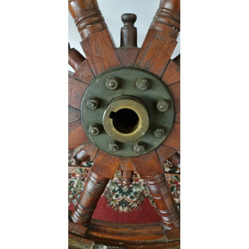 76 - A 20th century oak and brass bound ships wheel, central boss, mounted on three brass table legs, dia... 