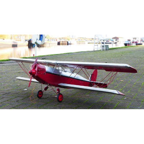 316 - A remote control model plane, dual wing, Irvine engine, red and silver livery with two figures in th... 