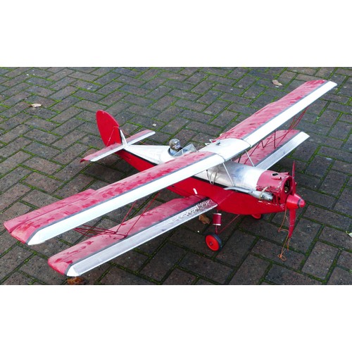 316 - A remote control model plane, dual wing, Irvine engine, red and silver livery with two figures in th... 