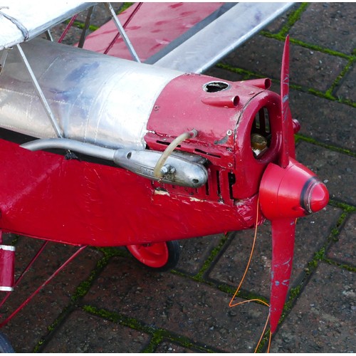 316 - A remote control model plane, dual wing, Irvine engine, red and silver livery with two figures in th... 