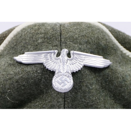 385 - A replica WWII German Waffen SS Crusher cap, with original badges.