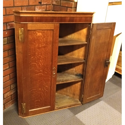 234 - A late 19th century George III style oak wall mounted corner cupboard, panelled door to internal she... 