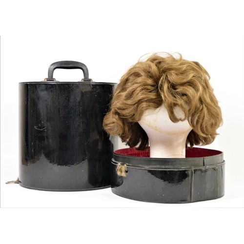 256 - Short, mid brown 1960's style wig in a black patent travel case , 35 x 27cm.