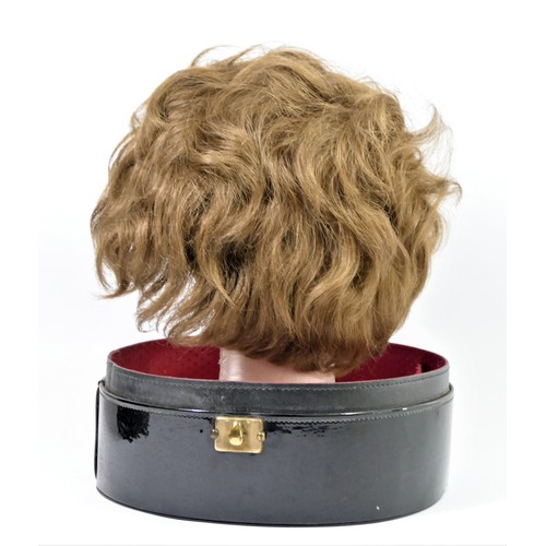 256 - Short, mid brown 1960's style wig in a black patent travel case , 35 x 27cm.