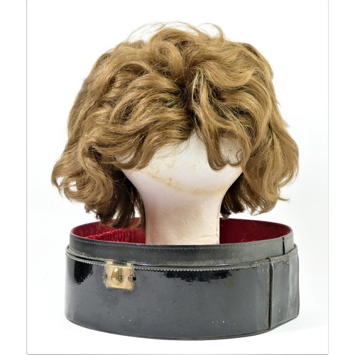 256 - Short, mid brown 1960's style wig in a black patent travel case , 35 x 27cm.